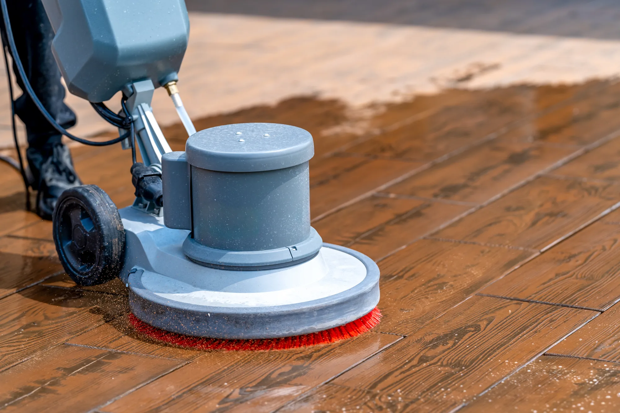 Professional hardwood floor cleaning technician buffing a solid oak floor in Georgia home